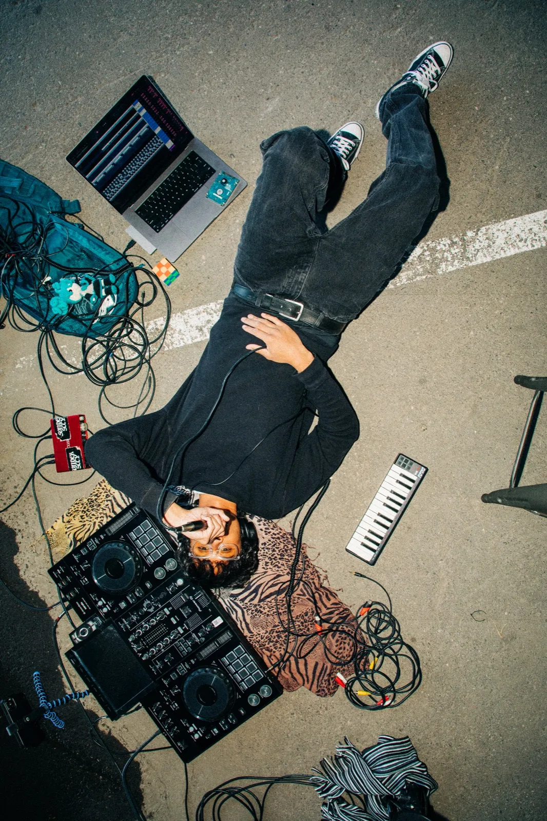 phaseeluv sprawled across pavement with a dj rig and laptop